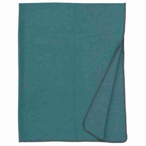 Solid turquoise throw by wooded river
